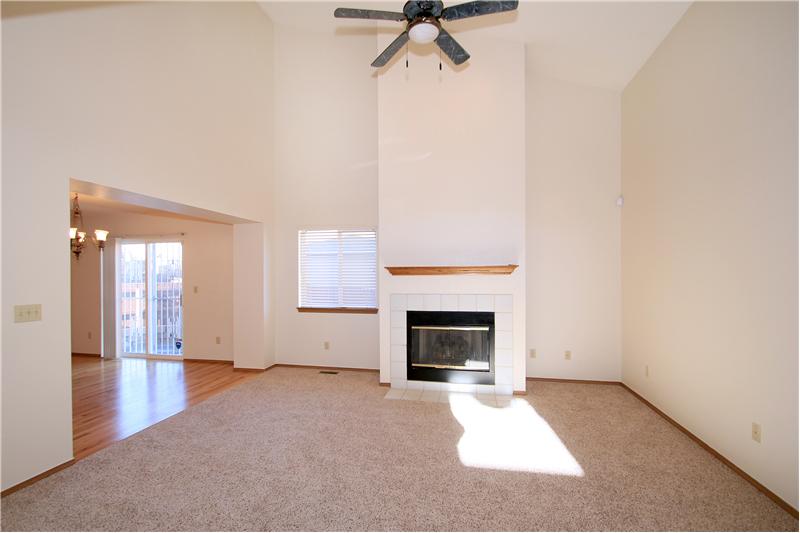 Large living room with gas fireplace, new carpet, and paint