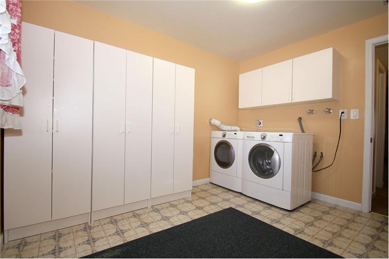 Large laundry room with a window and plumbed for a utility sink