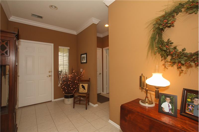 Spacious foyer with garage and laundry to the left with guest room to the right