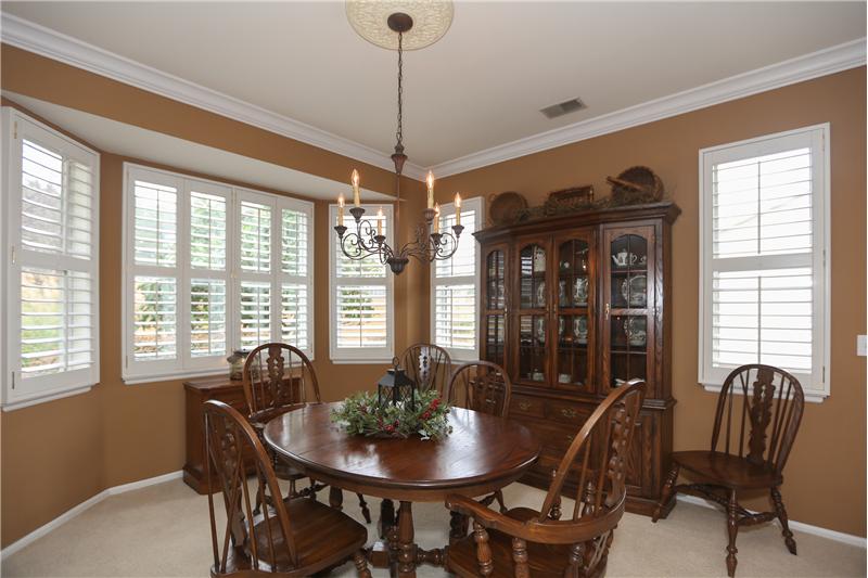 Dining room with beautiful bay windows with plantation shutters