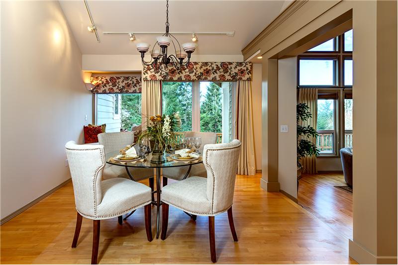Formal Dining Room with Gleaming Hardwood Floors, Vaulted Ceilings, Crown Molding, Window Bench and French Doors.